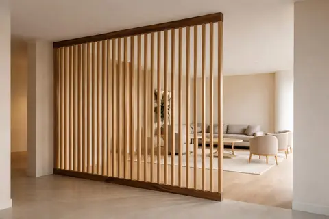 Claustra en chêne massif séparant circulation et salon, design intérieur minimaliste, finition mate et lumière naturelle.