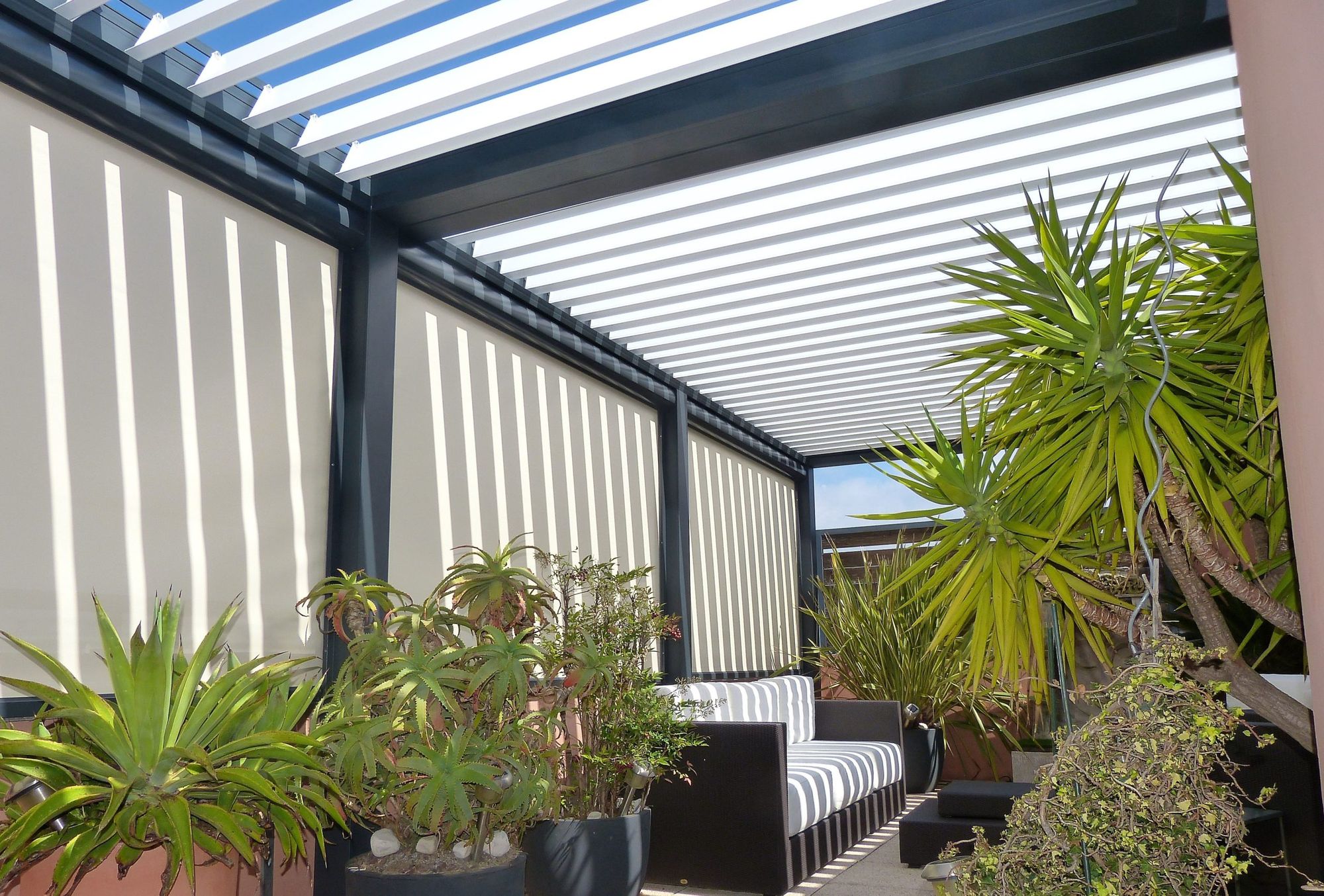 Pergola bioclimatique à lames orientables sur une terrasse