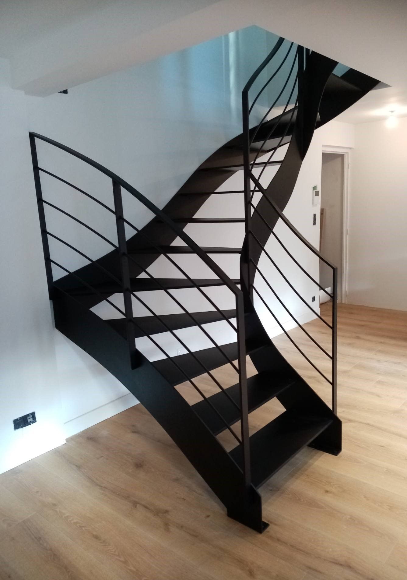 Escalier quart tournant en acier noir à marches suspendues