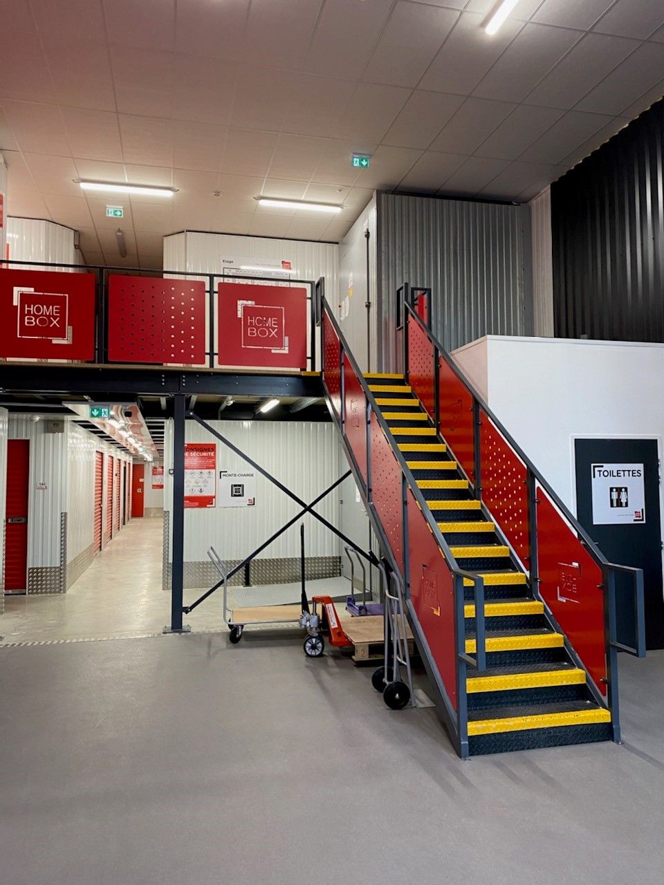Mezzanine de stockage en acier avec escalier et garde-corps dans un local d'activité
