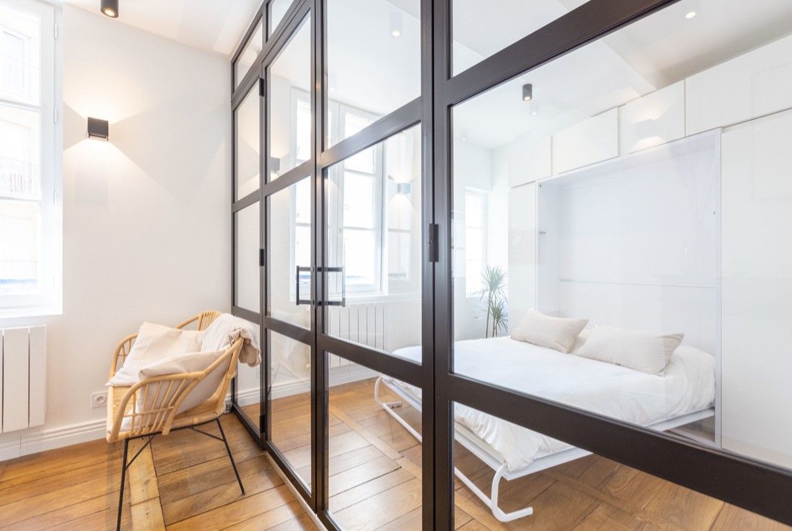 Verrière d'intérieur en acier noir séparant une chambre lumineuse