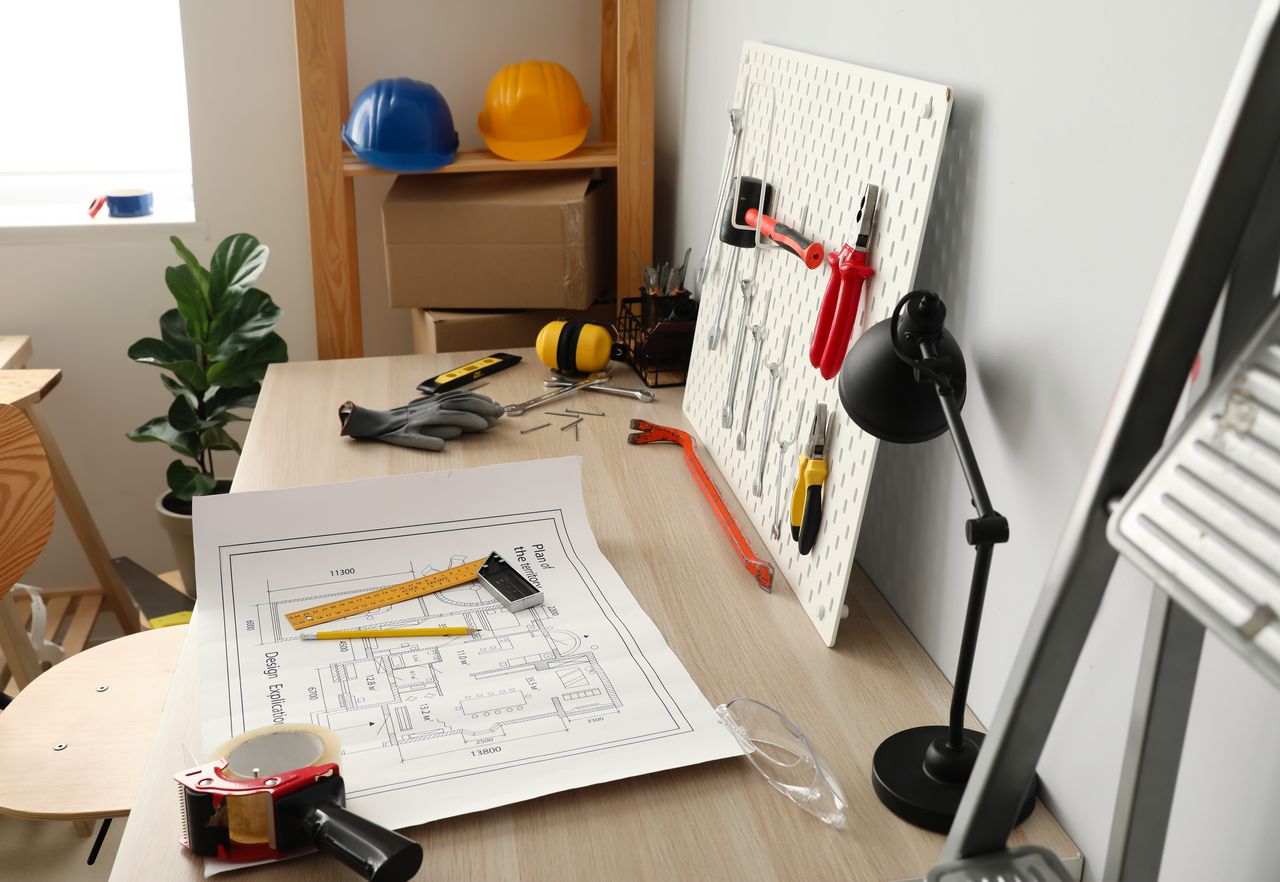 Plateau de bureaux en cours d’aménagement avec plans, échantillons matériaux, équipe chantier et mobilier prêt à installer