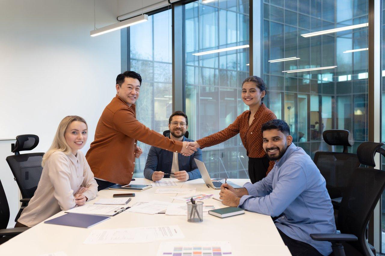 Une équipe commerciale collaborative utilisant des outils digitaux lors d'une réunion pour renforcer la performance commerciale.